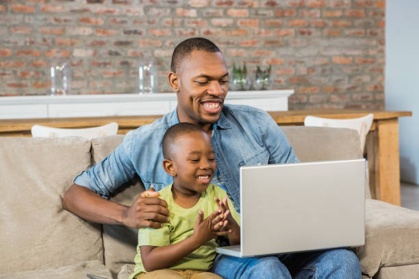 istock Father and son using laptop on the couch 661540752