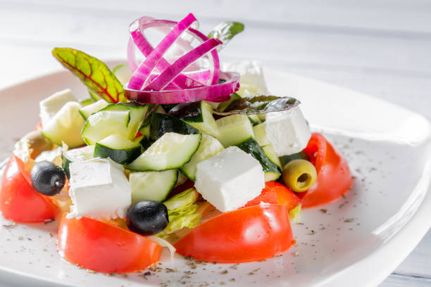 istock Fresh Greek salad on white plate with onion. Close up with selective focus 661551214