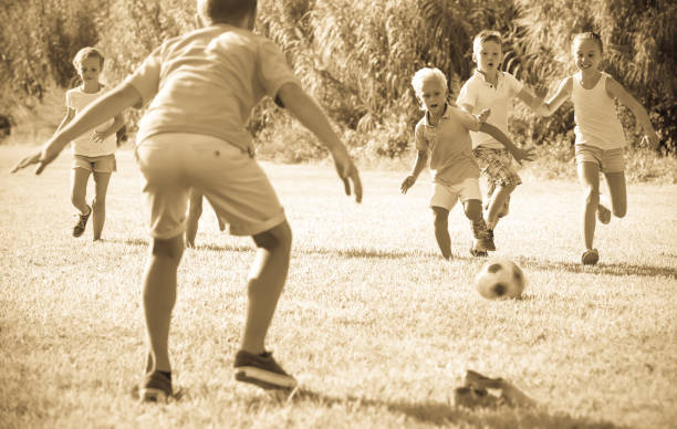 istock children playing football on meadow 661563928