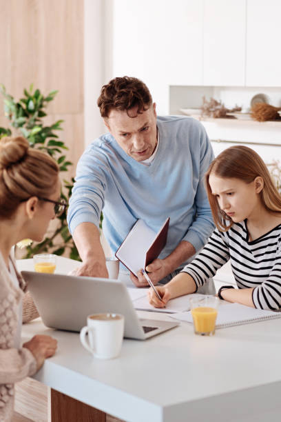 istock Serious loving parents helping their daughter with homework 661574254