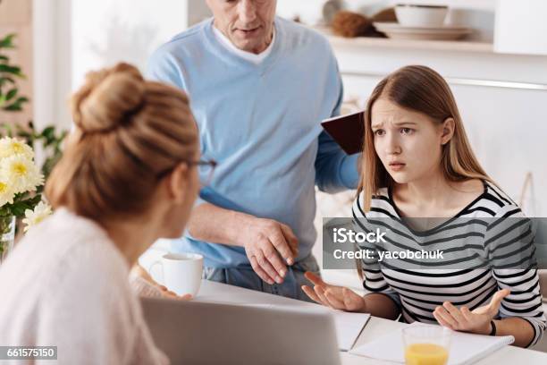 Sad Girl Doing Homework With Her Parents Stock Photo - Download Image Now - Teenager, Father, Mother