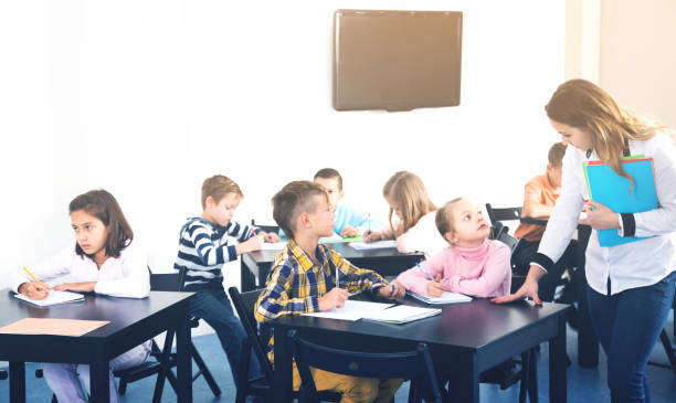 istock Little children with teacher in classroom 661580810