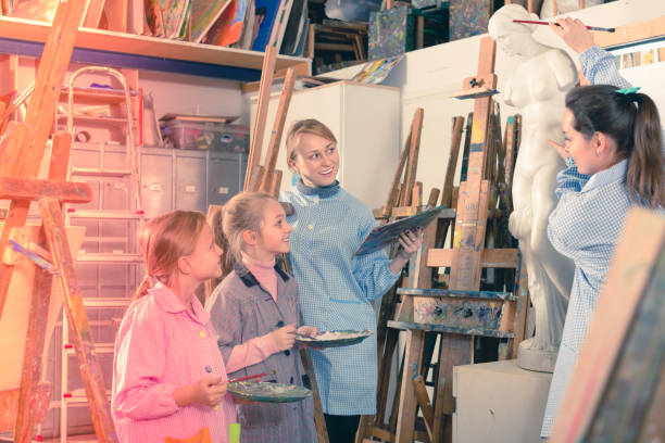 istock Female teacher talking about painting methods 661597574