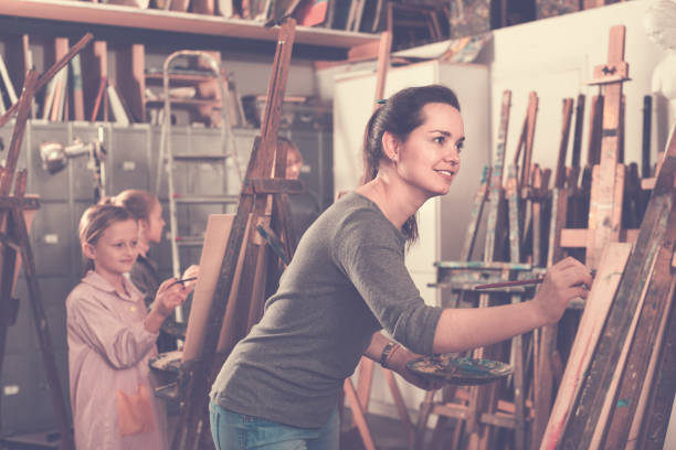 istock Students working patiently during painting class at art studio 661597634