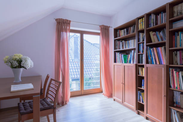 Adorable reading room for book lovers Romantic attic reading room with a large fitted book cabinet dealing room photos stock pictures, royalty-free photos & images