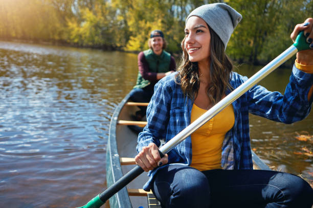 This is how they do weekends Shot of a young couple going for a canoe ride on the lake canoeing stock pictures, royalty-free photos & images