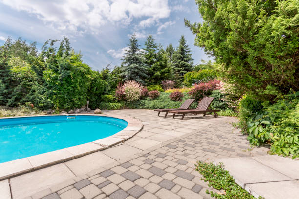 istock Oval swimming pool with sunbeds 661628674