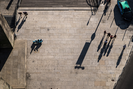 Group of people walking and chatting as seen from above a bridge in Lisbon