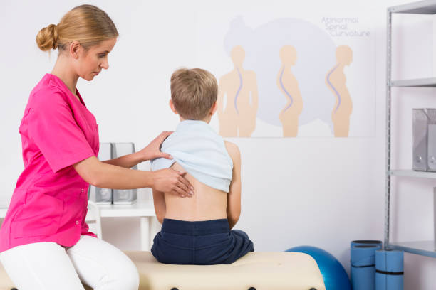 子供の姿勢を調べる医師 - scoliosis ストックフォトと画像