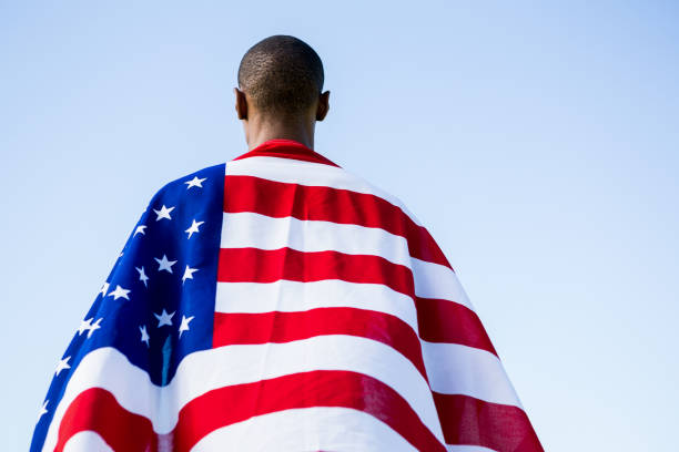 Young Hispanic student with American flag over his head.
