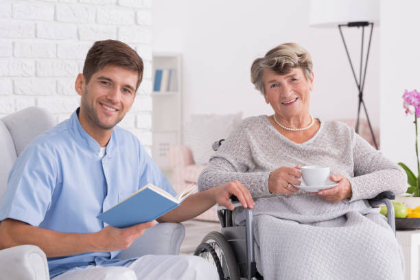 istock Smiling senior on wheelchair with assistant 661656526