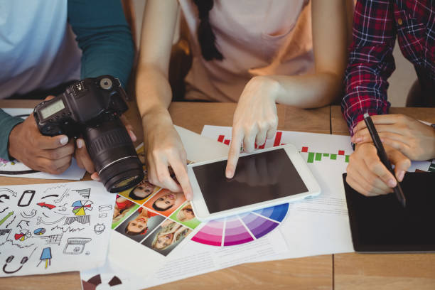 istock Mid section of graphic designers interacting with each other while working 661672262