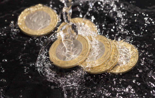 istock coins in water splashes on a black background 661683166