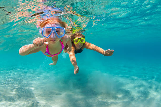 Mother with child swim underwater with fun in sea Happy family - mother with baby girl dive underwater with fun in sea pool. Healthy lifestyle, active parent, people water sport outdoor adventure, swimming lessons on beach summer holidays with child underwater diving stock pictures, royalty-free photos & images
