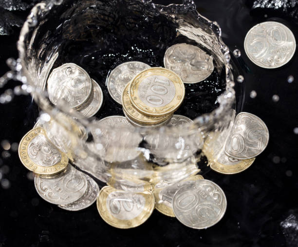 istock coins in water splashes on a black background 661693658