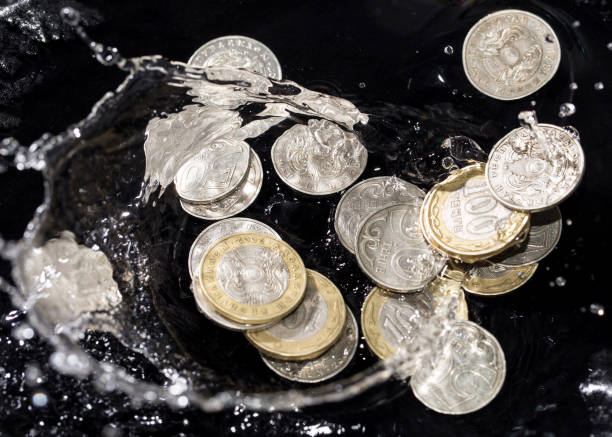 istock coins in water splashes on a black background 661694836