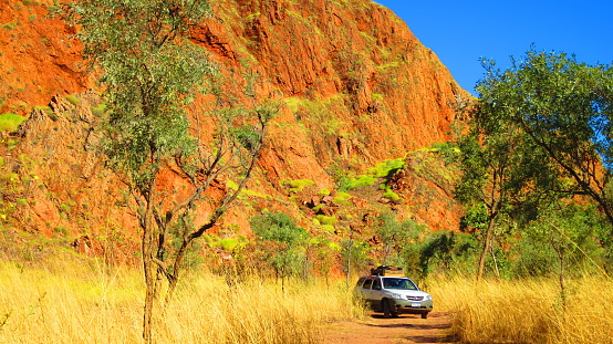 Outback Australia - backpackers driving a 4x4 four wheel drive jeep off road through dirt track to camping spot near Lake Argyle