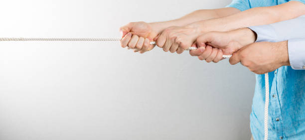 together we are stronger. Two men pulling a rope stock photo