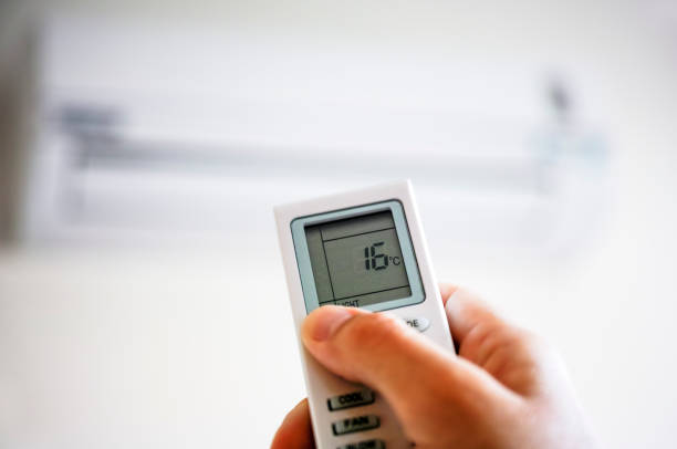 istock Person hand using remote control of air conditioner. 661712824