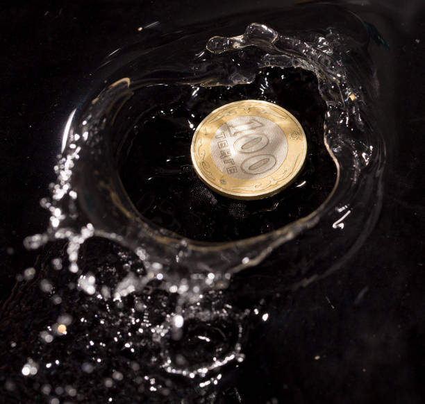 istock coins in water splashes on a black background 661713212