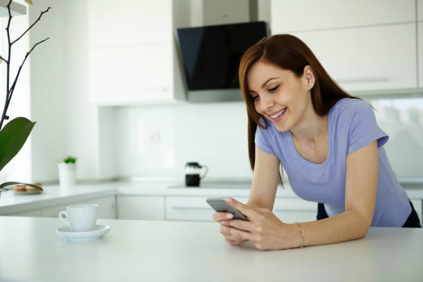 istock Smiling woman checking messages at home 661750478