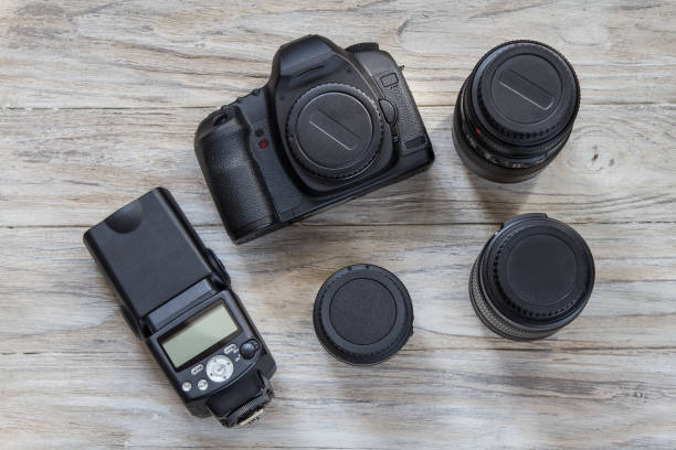 istock Camera and camera lens on a wooden background, top view 661769986