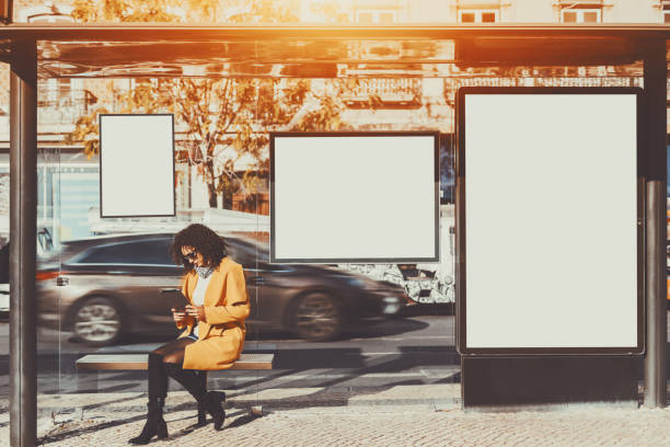 istock Woman inside of bus stop with several mock-up banners 661777098