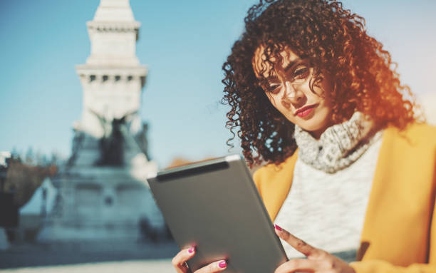 istock Beautiful curly Brazilian lady with digital tablet 661777848