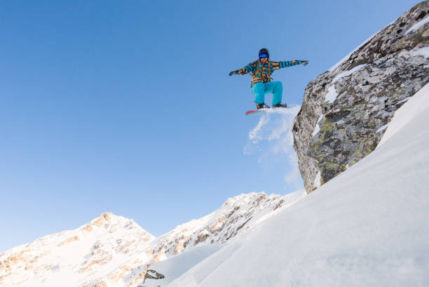 istock Extreme male snowboarder jumping from a cliff 661799102