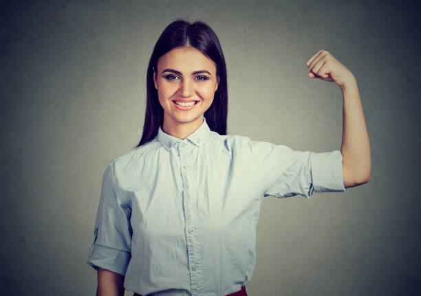 istock Young happy woman flexing muscles showing strength 661806172