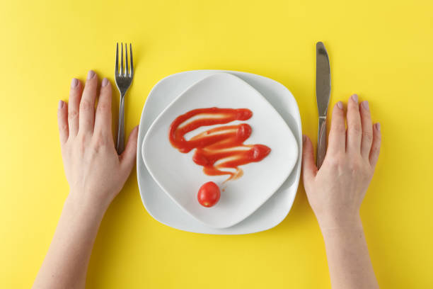istock White dish with ketchup shaped, hands with knife and fork 661828398