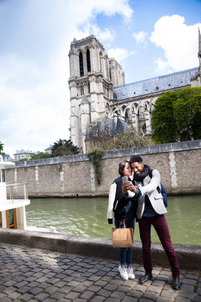 casal jovem multi-étnica tomar selfie juntos em notre-dame pelo sena em paris - seine net fotos - fotografias e filmes do acervo