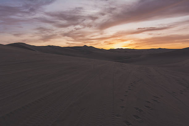 istock Foot Prints And Tire Tracks On Sand In Desert 661832277