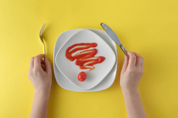 istock woman two hands hold a spoon and fork and white dish on yellow background 661834880