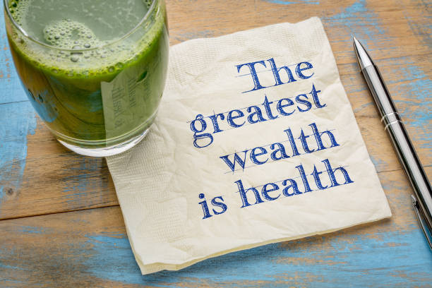 The greatest wealth is health advice or reminder - handwriting on a napkin with a glass of fresh, green, vegetable juice