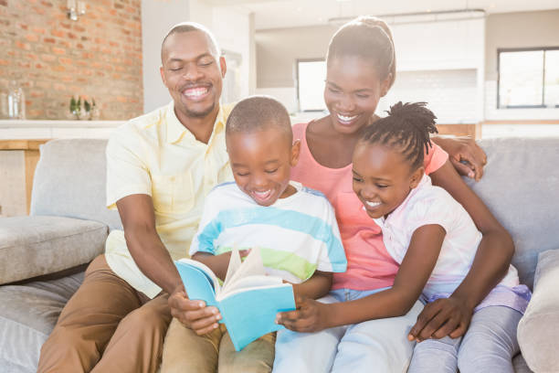 istock Happy family reading a book together 661880034