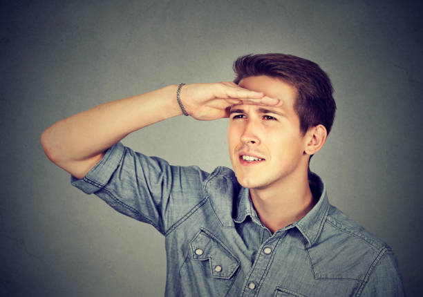 istock Young man holding his hand at forehead looking far away. 661884652