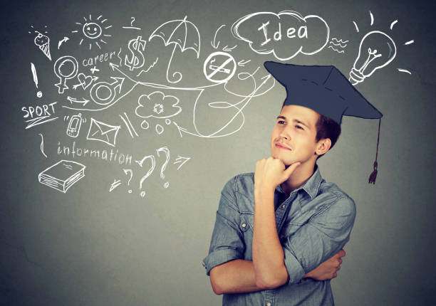 istock Young handsome man with graduation hat looking up thinking about education has many ideas about future life 661884904
