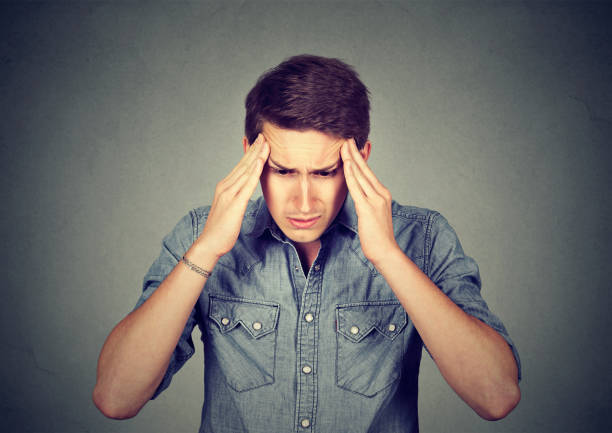istock Stressed man with a headache isolated on gray wall background 661895644