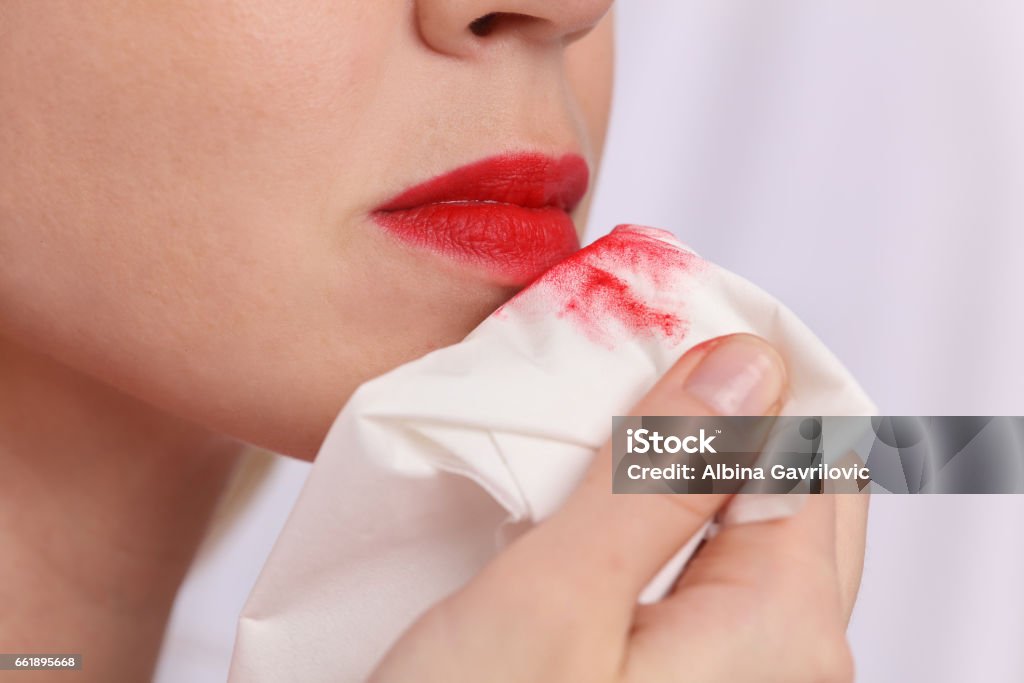 女性はクリーンアップ化粧水でメイクアップを削除します。ホワイトペーパーナプキンに赤い口�紅のマーク - 化粧を落とすのロイヤリティフリーストックフォト