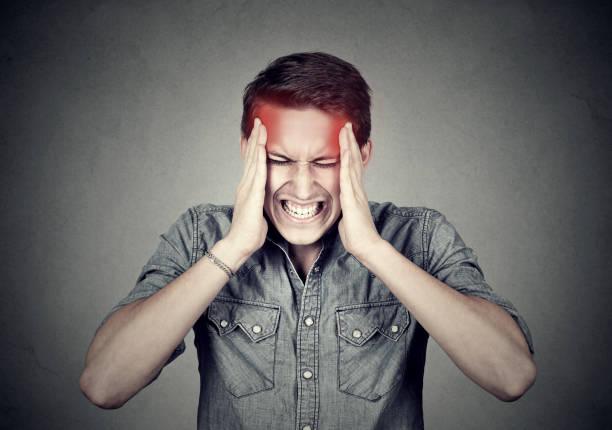 stressed man with headache isolated on gray wall background - heat effort emotional stress business imagens e fotografias de stock