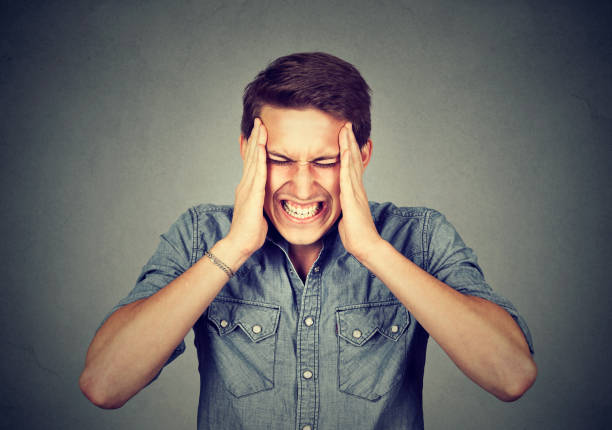 stressed man with headache isolated on gray wall background - heat effort emotional stress business imagens e fotografias de stock