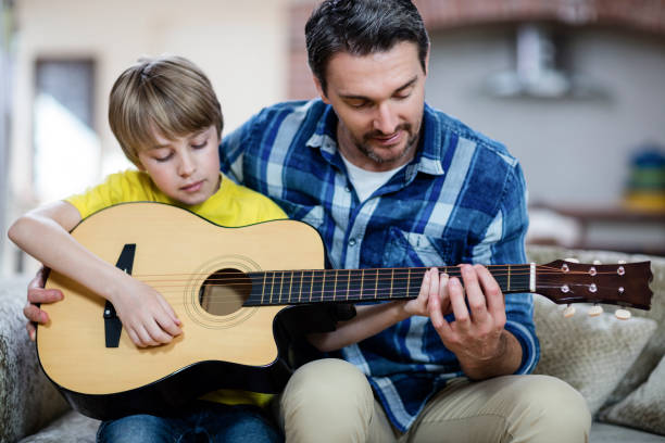 istock Father and son playing a guitar 661898852