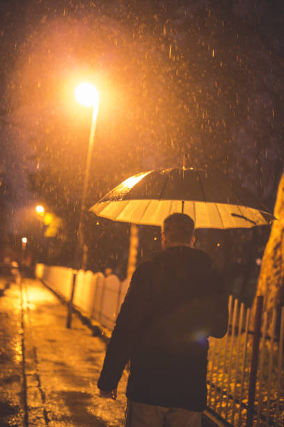 istock Man walking at night in the rain. 661911480