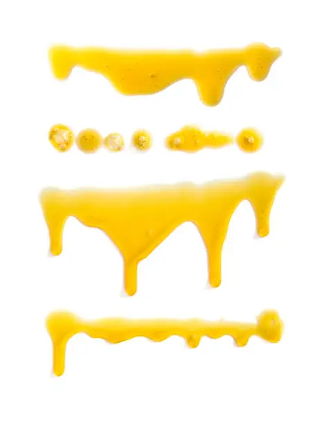 Photo of Set of stains of yellow oil and drops on a white background