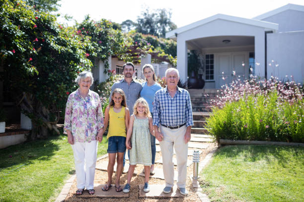 istock Multi-generation family standing on the garden path 661946662