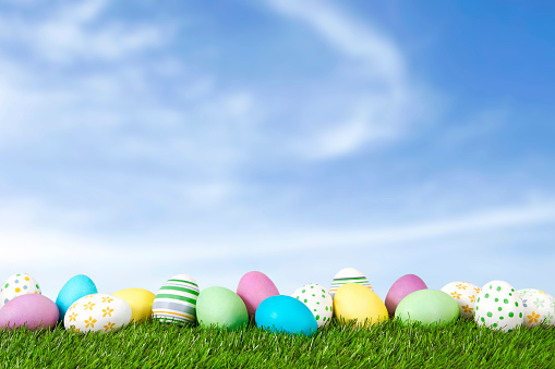 Easter Eggs on green grass with blue sky.