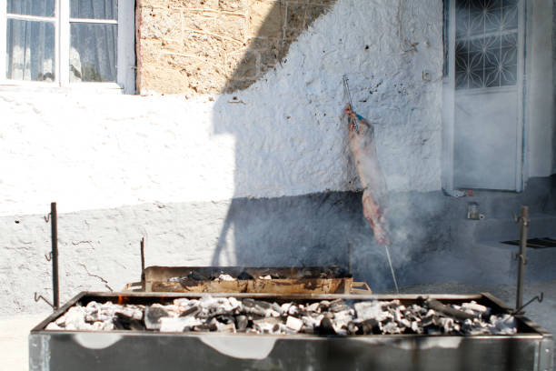 barbeque and lamb in background on spit on fire grill