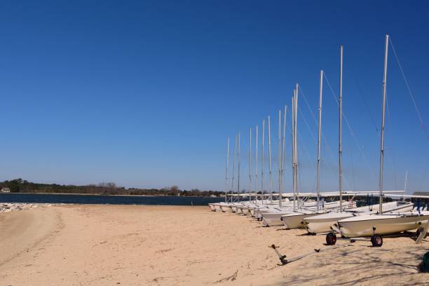A line of small sailboats line the beach in Oxford, Maryland waiting for the spring tourist season to kick off so they can go swimming
