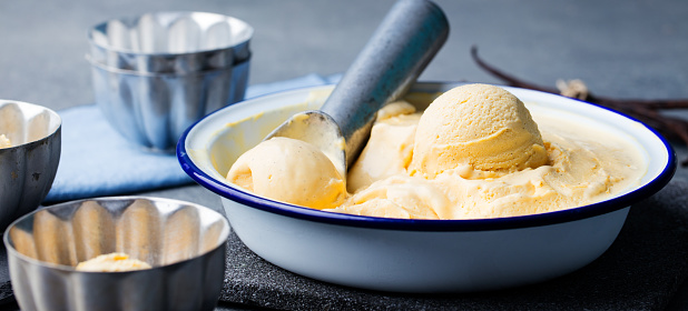 Homemade vanilla, caramel ice cream in vintage bowl. Organic product on a grey stone background